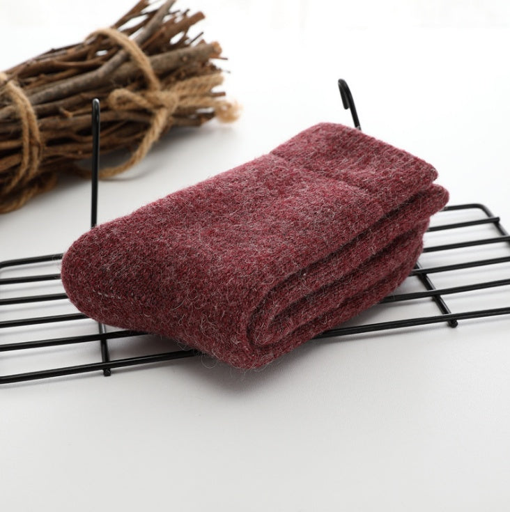 Folded maroon sock on a black wire rack with twigs in the background