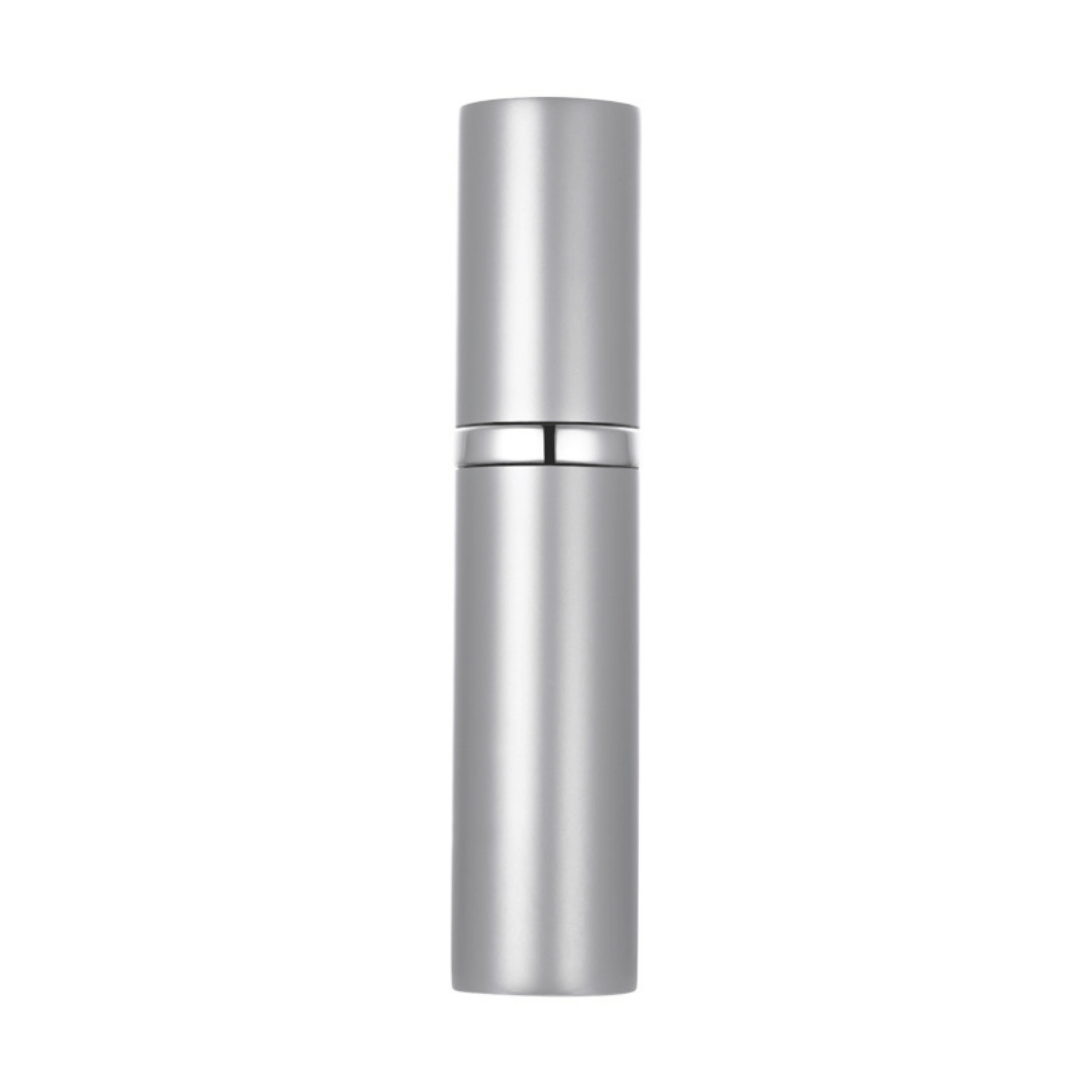 A hand holding a black travel-size perfume atomizer with a fine spray of perfume, highlighting the product's capability to spray without water drops.