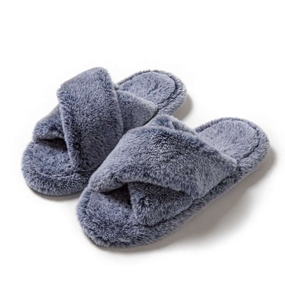 Pair of fluffy blue slippers on a white background