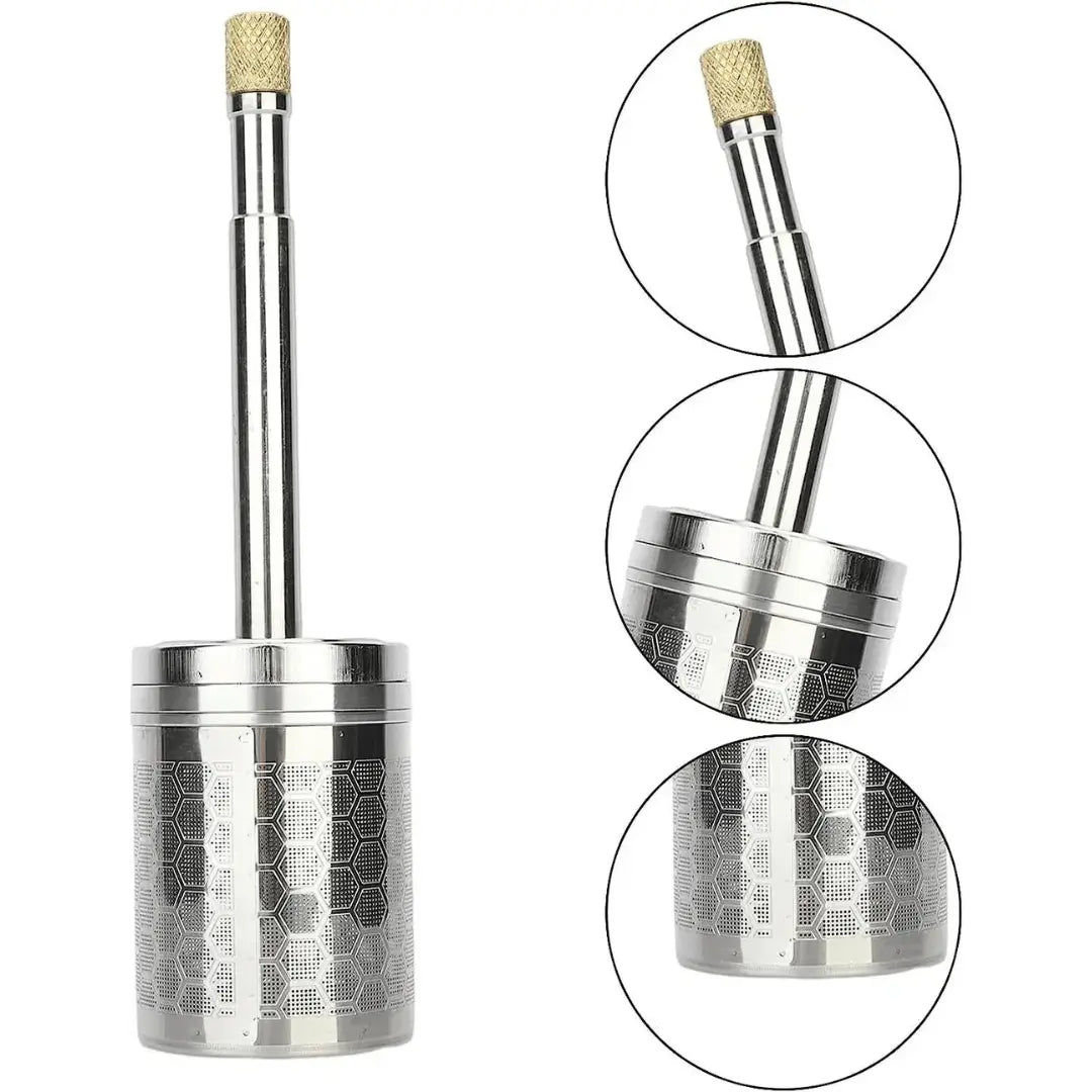 A stainless steel AromaPress lying on a bed of coffee beans, suggesting a connection to coffee brewing.