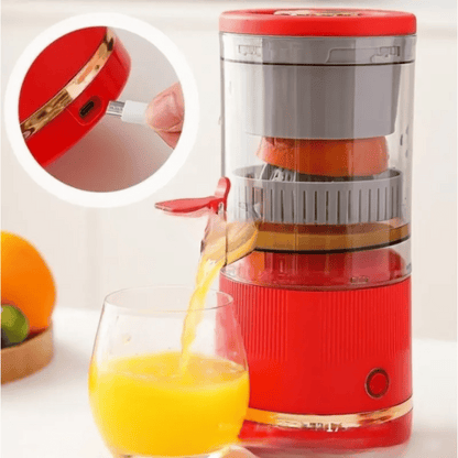 Red manual juicer with a glass of orange juice on a white background