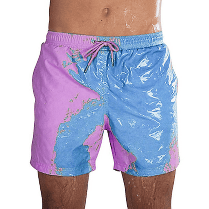 A collection of SplashShift Shorts in various colors, featuring a man modeling the yellow pair, with other pairs shown in blue, orange, and green splattered patterns.