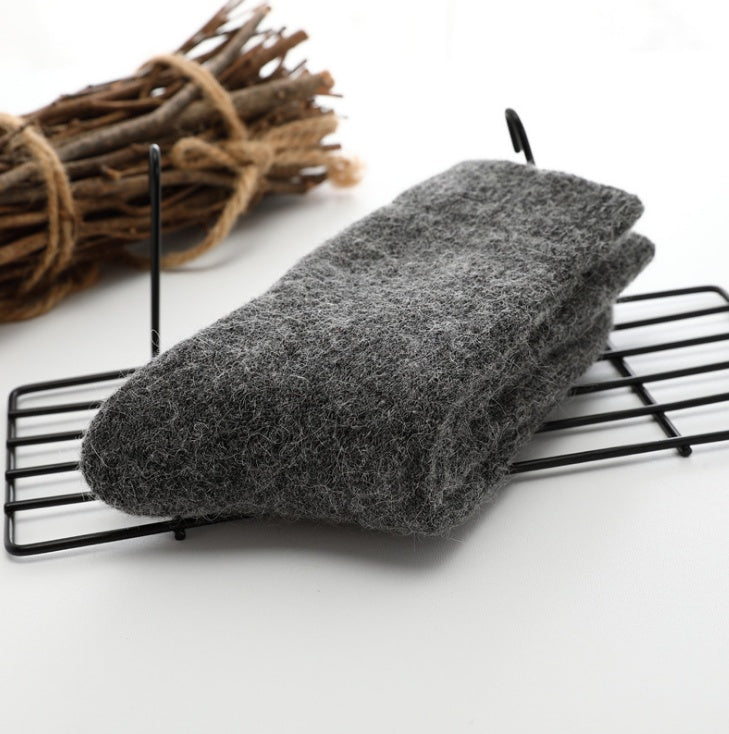 Gray scrubber on a black wire rack with twigs in the background