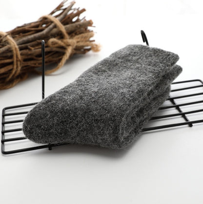 Gray scrubber on a black wire rack with twigs in the background
