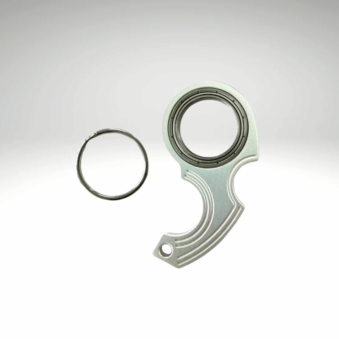 A keychain fidget spinner accessory disassembled into two pieces, a black main component and a metallic ring, displayed against a white background.