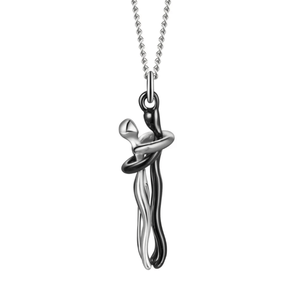 A sleek and artistic silver necklace with a pendant in a hugging design, symbolizing love and connection.