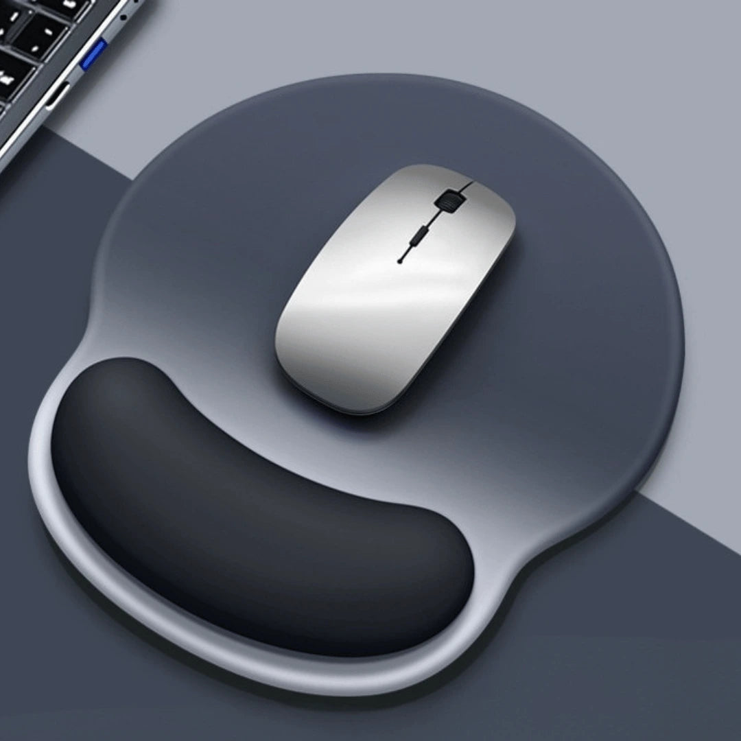 Silver computer mouse on a dark gray mouse pad with a laptop corner visible.