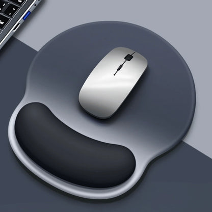 Silver computer mouse on a dark gray mouse pad with a laptop corner visible.