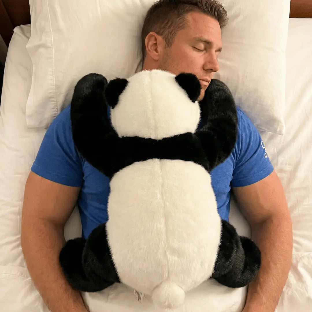 Man sleeping with a panda-shaped pillow on white bedding