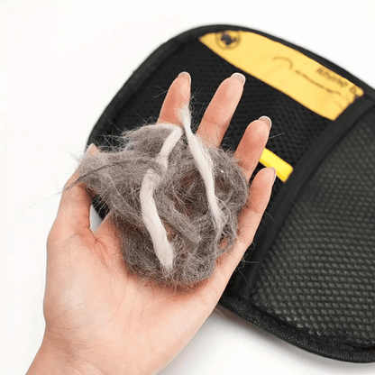 Hand holding pet hair next to a grooming tool with a visible brand logo.