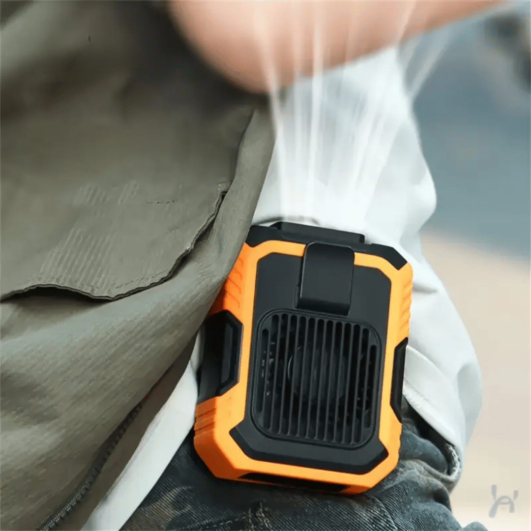 A portable orange and black fan attached to a belt, with a person's pants in the background.