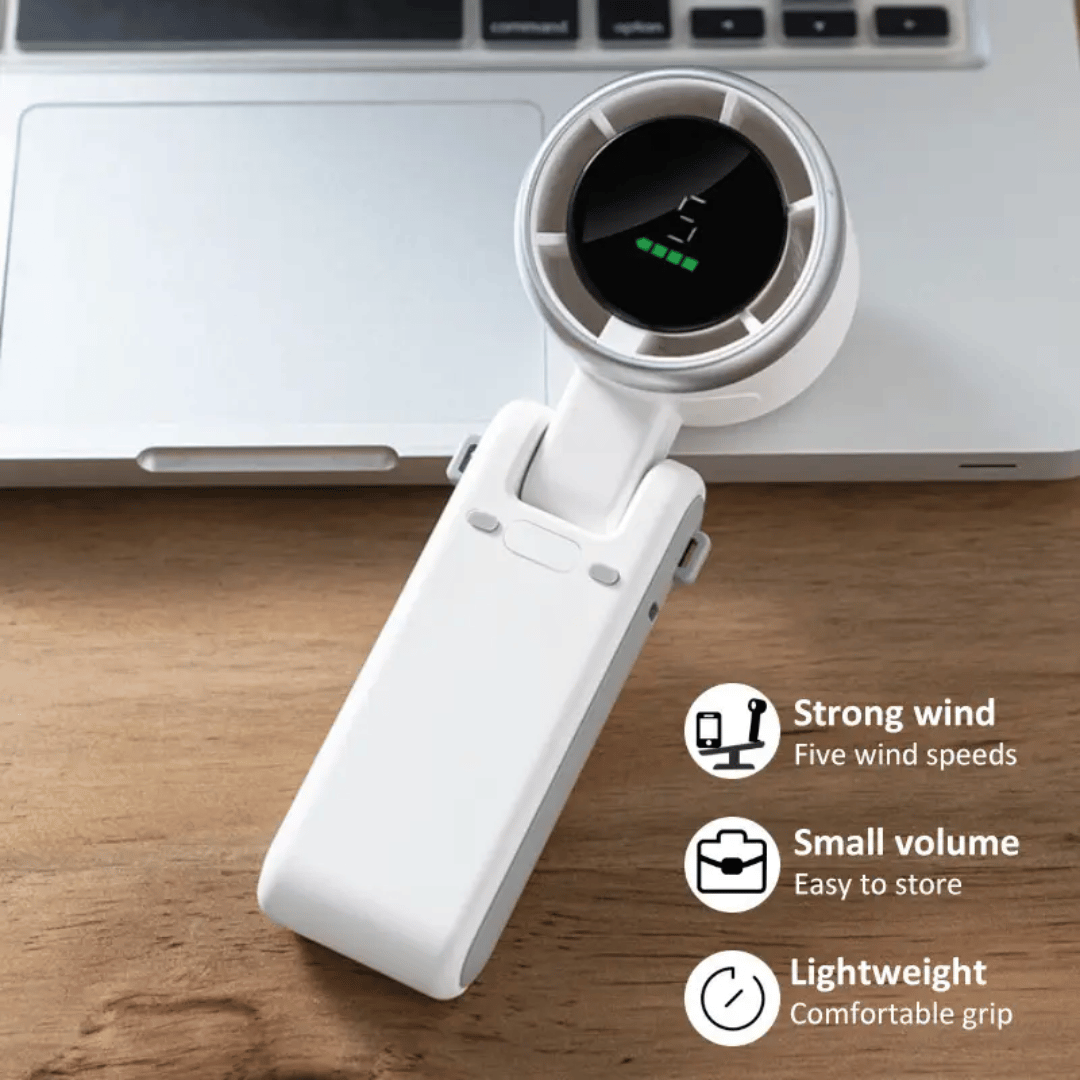 White handheld fan on a wooden surface with laptop in the background
