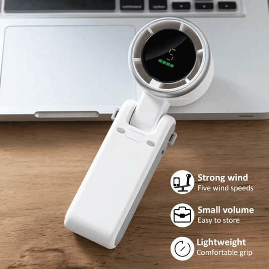 White handheld fan on a wooden surface with laptop in the background