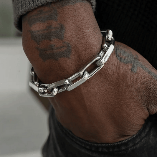 A close-up image of a person's wrist wearing a silver Urban Forge Bracelet.
