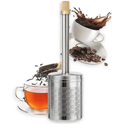 A stainless steel AromaPress lying on a bed of coffee beans, suggesting a connection to coffee brewing.