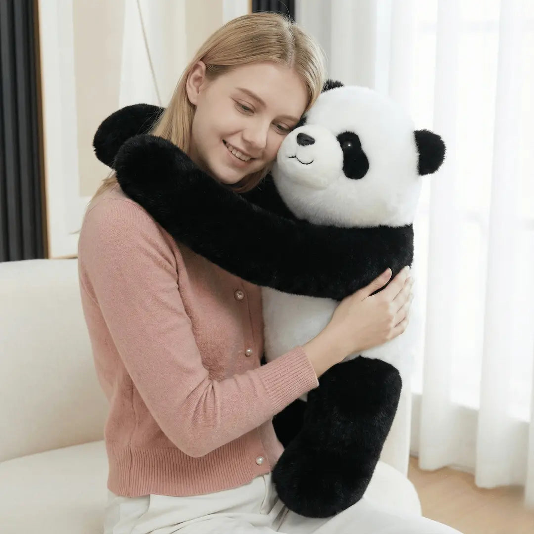 Woman hugging a large panda-shaped pillow in a cozy living room.