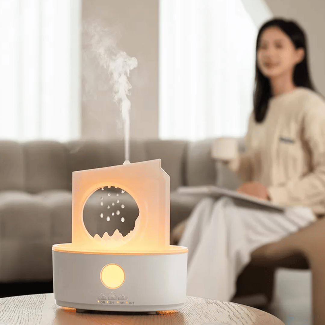 Aroma diffuser emitting steam with a blurred person sitting on a couch in the background