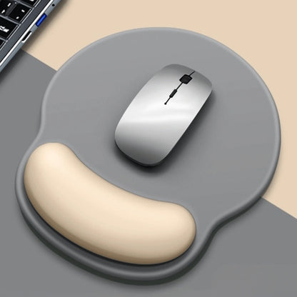 Gray mouse pad with wrist rest and wireless mouse on a beige surface