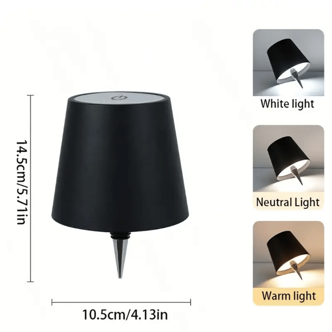 A lamp with a black shade placed on a bottle which appears to be a whiskey bottle with a label.