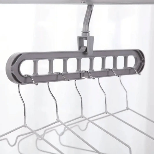 A set of multi-functional space-saving hangers arranged in a wardrobe, holding various garments.