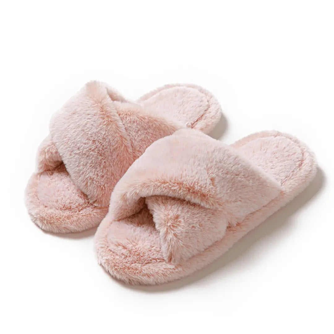 Pair of pink fluffy slippers on a white background
