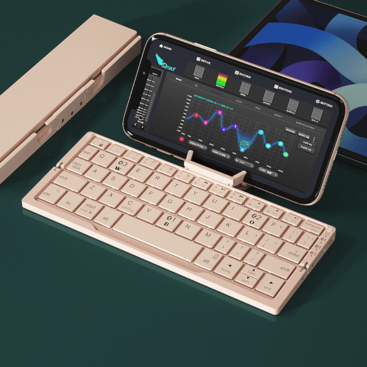 Foldable keyboard and phone stand on a dark surface with a phone displaying a music app.