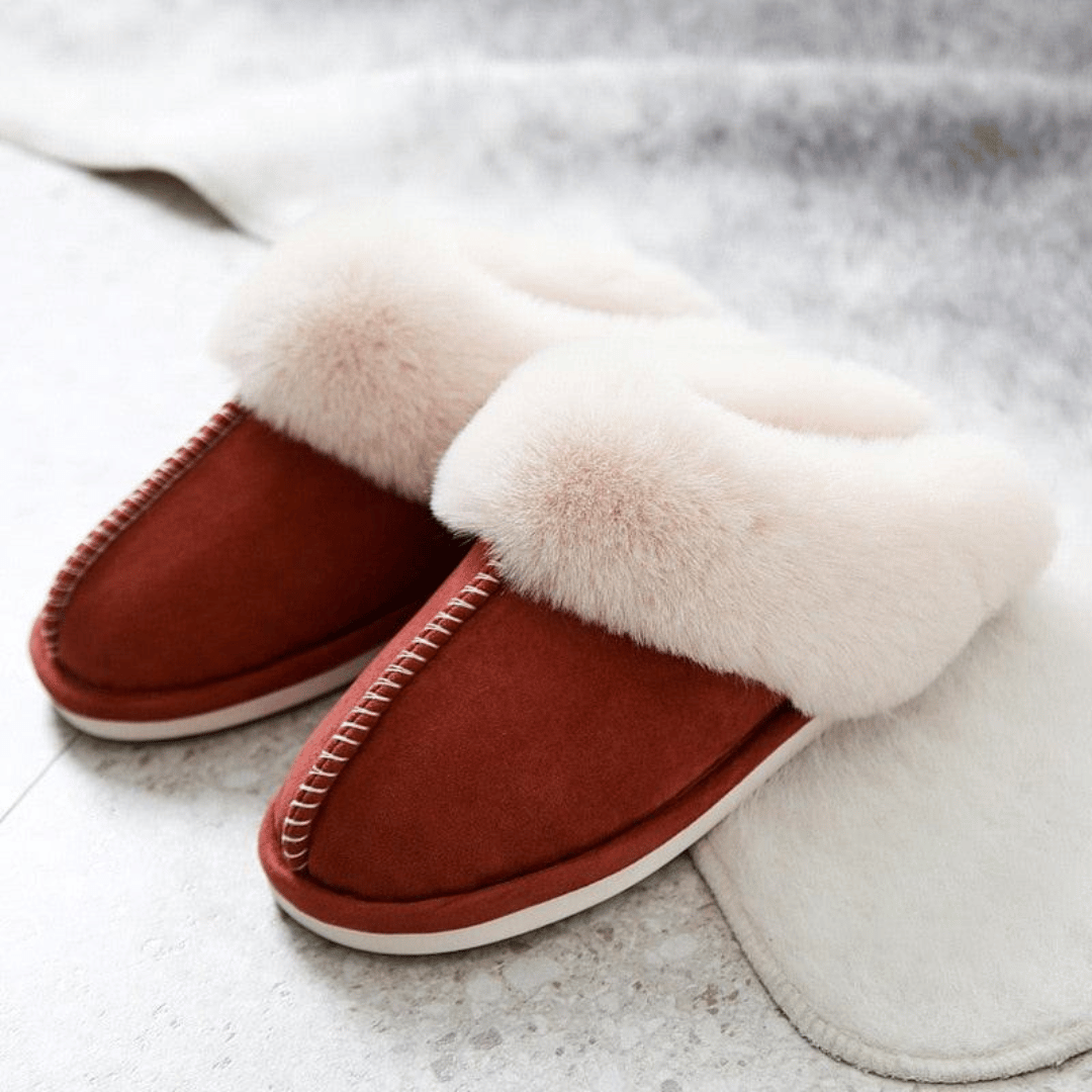 Red slippers with fluffy white fur on a light background