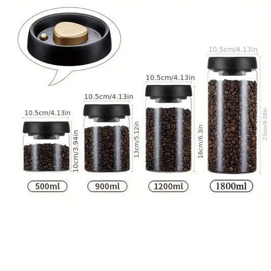 A set of press-seal glass canisters of various sizes with matte black lids featuring a luxurious gold accent, filled with what appears to be coffee beans.