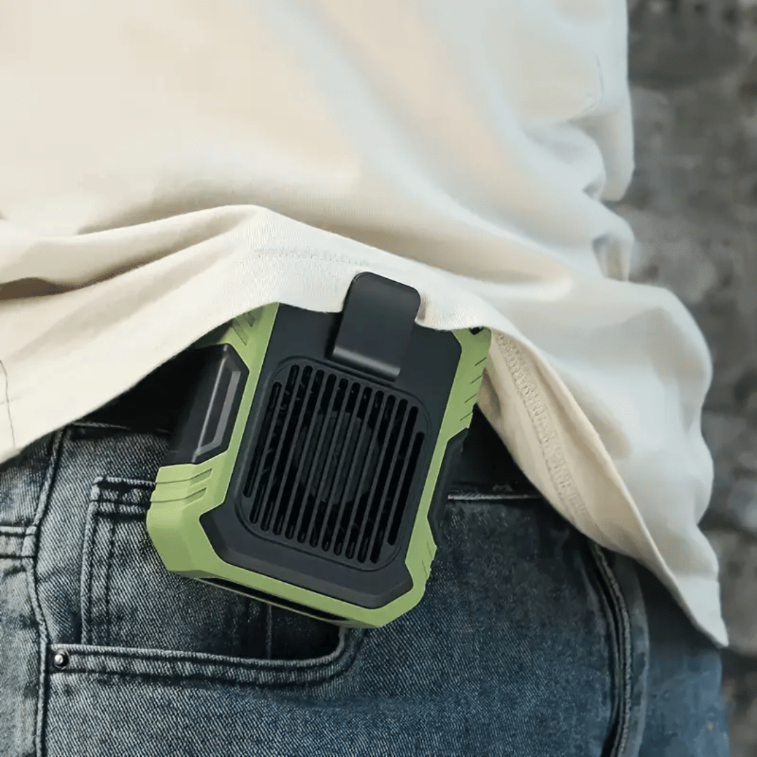 A portable orange and black fan attached to a belt, with a person's pants in the background.