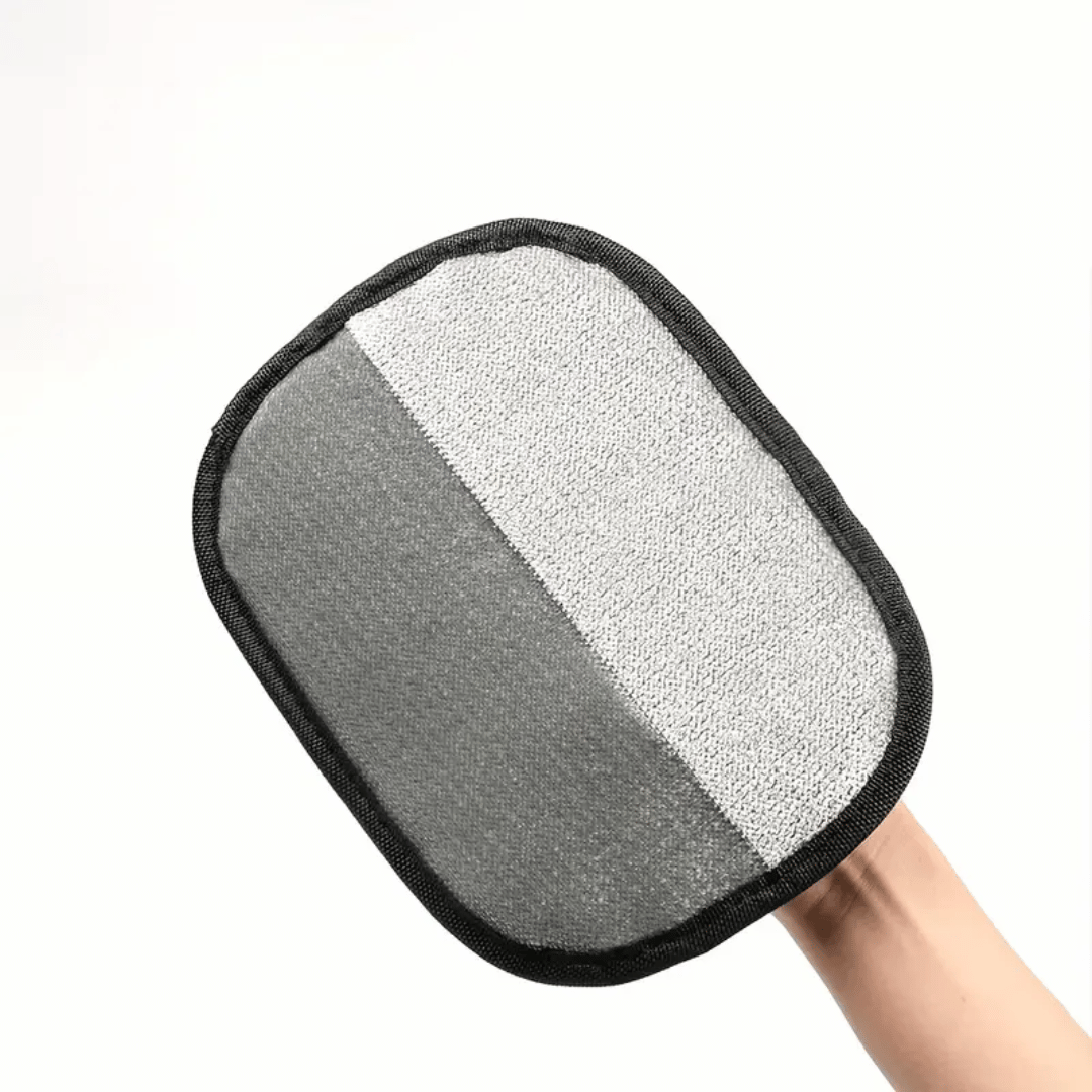 Gray scrubber pad held by a hand on a white background