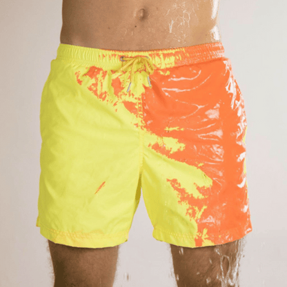 A collection of SplashShift Shorts in various colors, featuring a man modeling the yellow pair, with other pairs shown in blue, orange, and green splattered patterns.