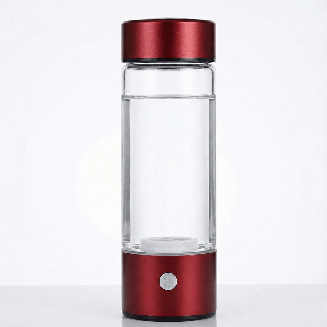 Clear glass water bottle with red metal cap and base on a white background