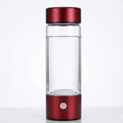 Clear glass water bottle with red metal cap and base on a white background