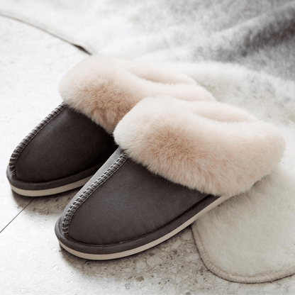 Gray slippers with fluffy white fur on a light background