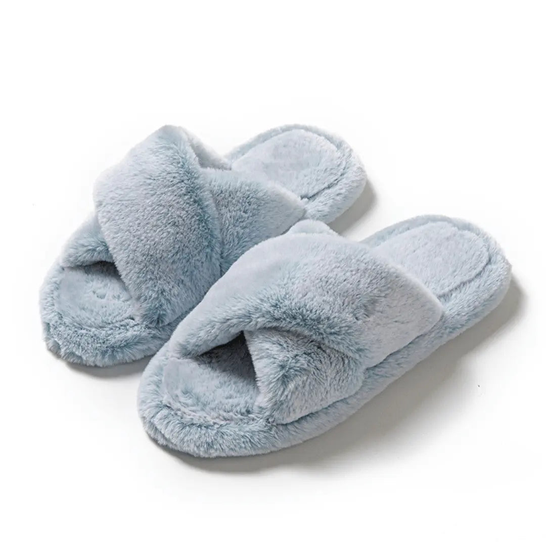 Pair of light blue fluffy slippers on a white background