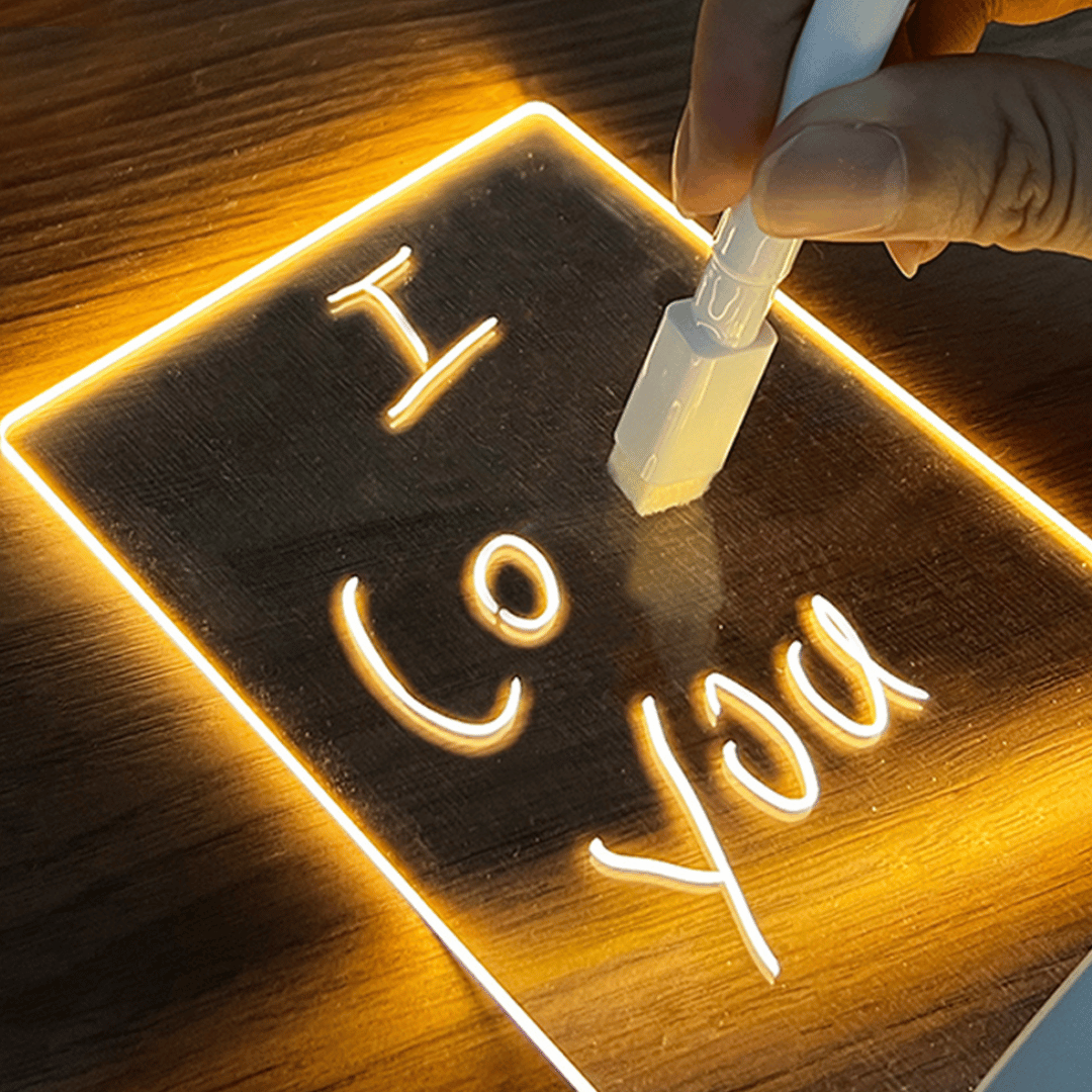 Neon sign with 'I Love You' text being written on a wooden surface.