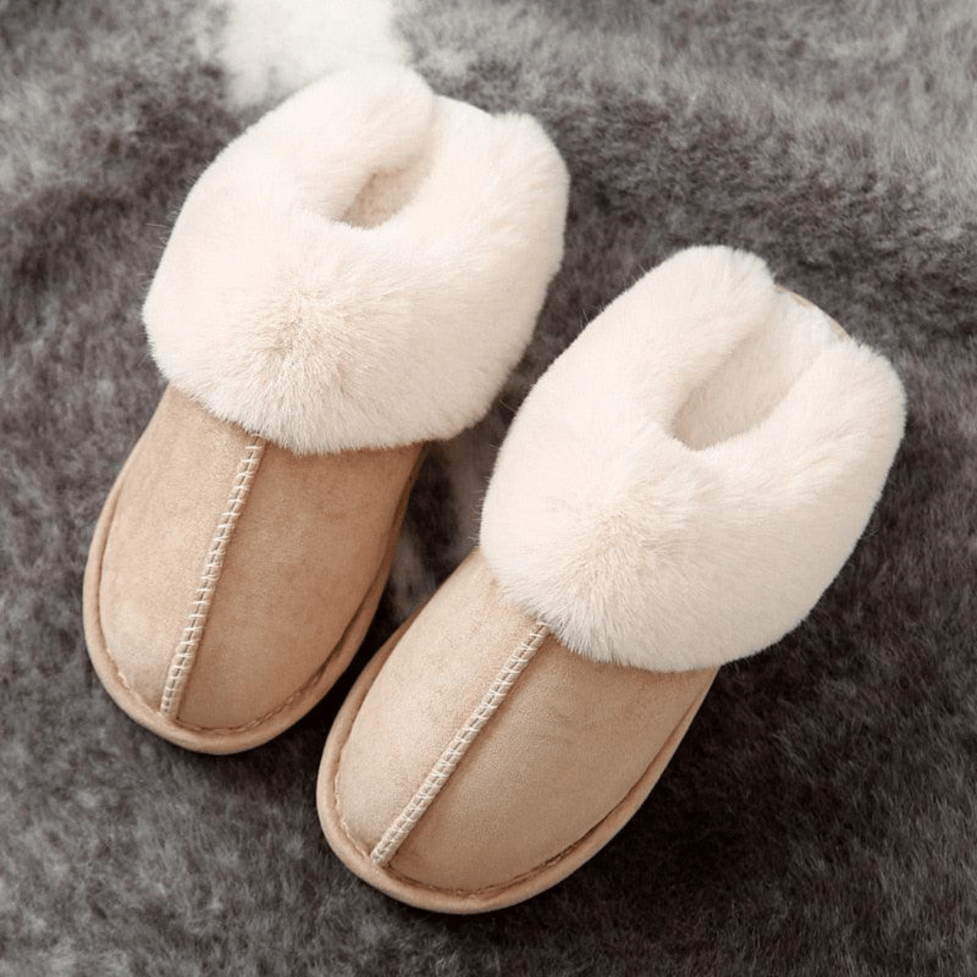 Beige slippers with fluffy white fur on a gray background