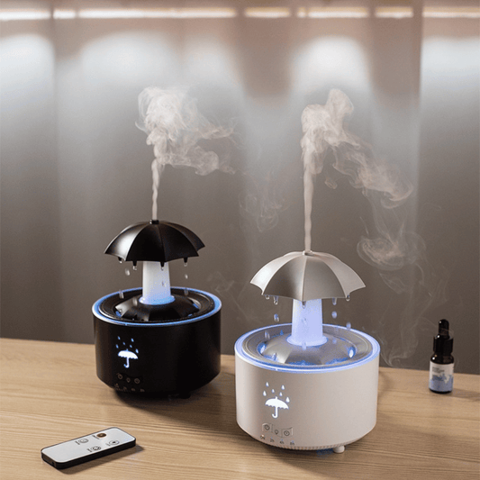 Two humidifiers shaped like umbrellas on a wooden surface with a remote control.