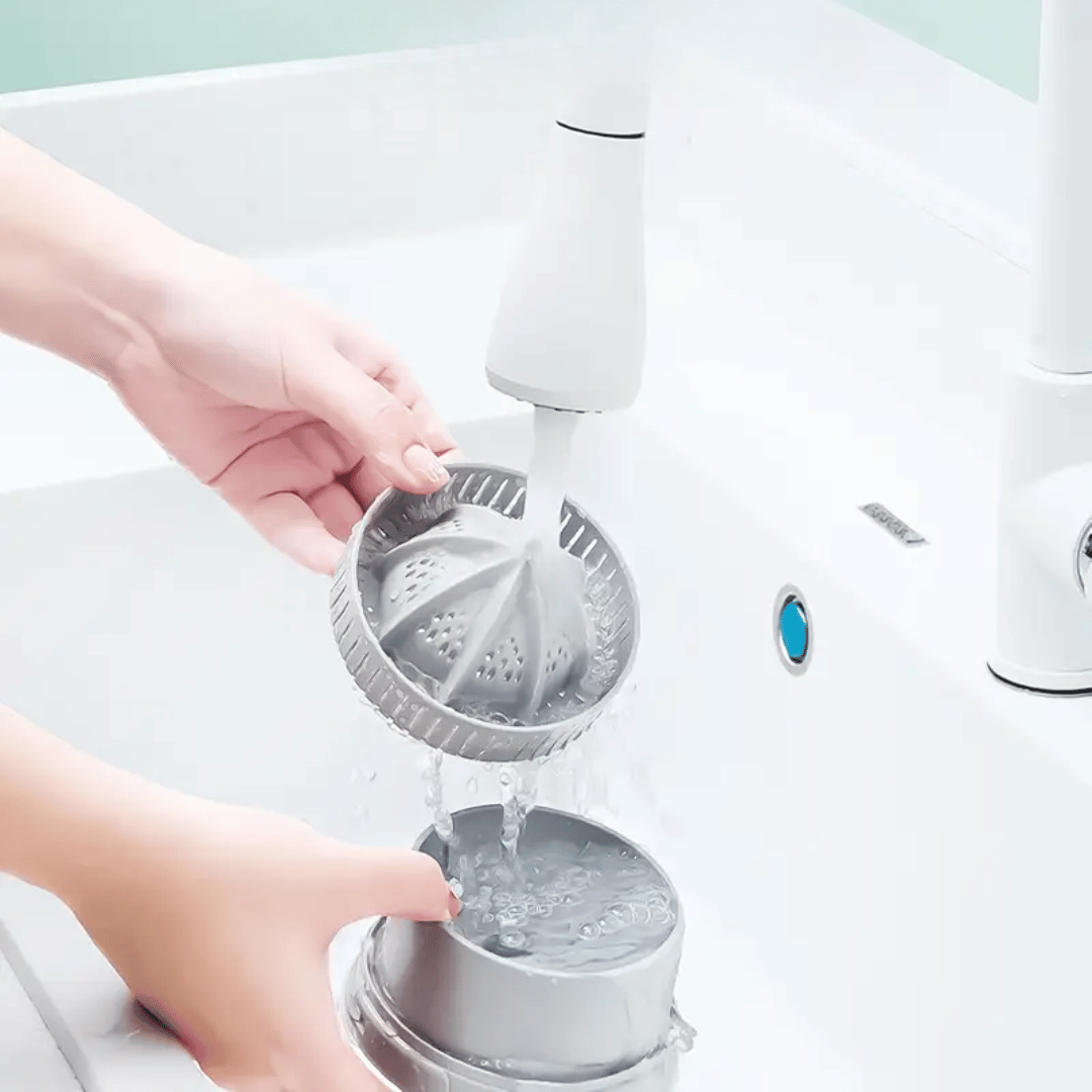 Person using a handheld showerhead with water flowing, on a light green background