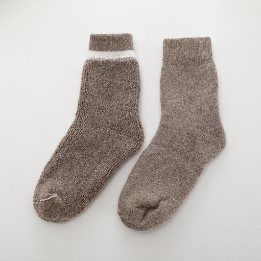 Pair of brown fuzzy socks on a white background