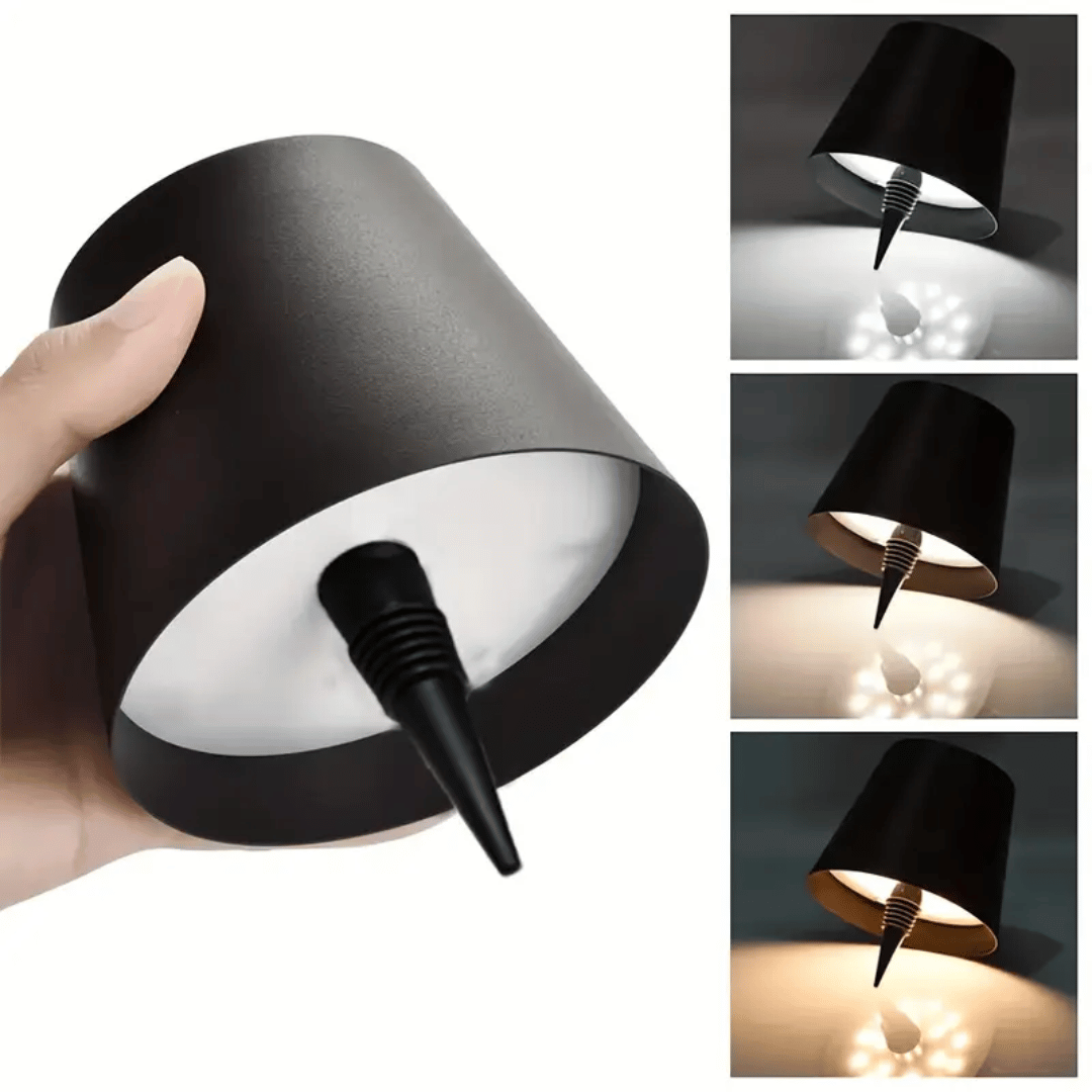 A lamp with a black shade placed on a bottle which appears to be a whiskey bottle with a label.
