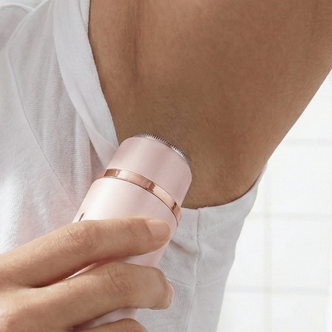 Pink and rose gold epilator being used on a person's arm.