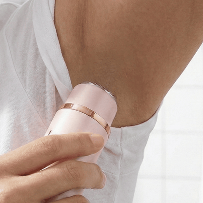 Pink and rose gold epilator being used on a person's arm.